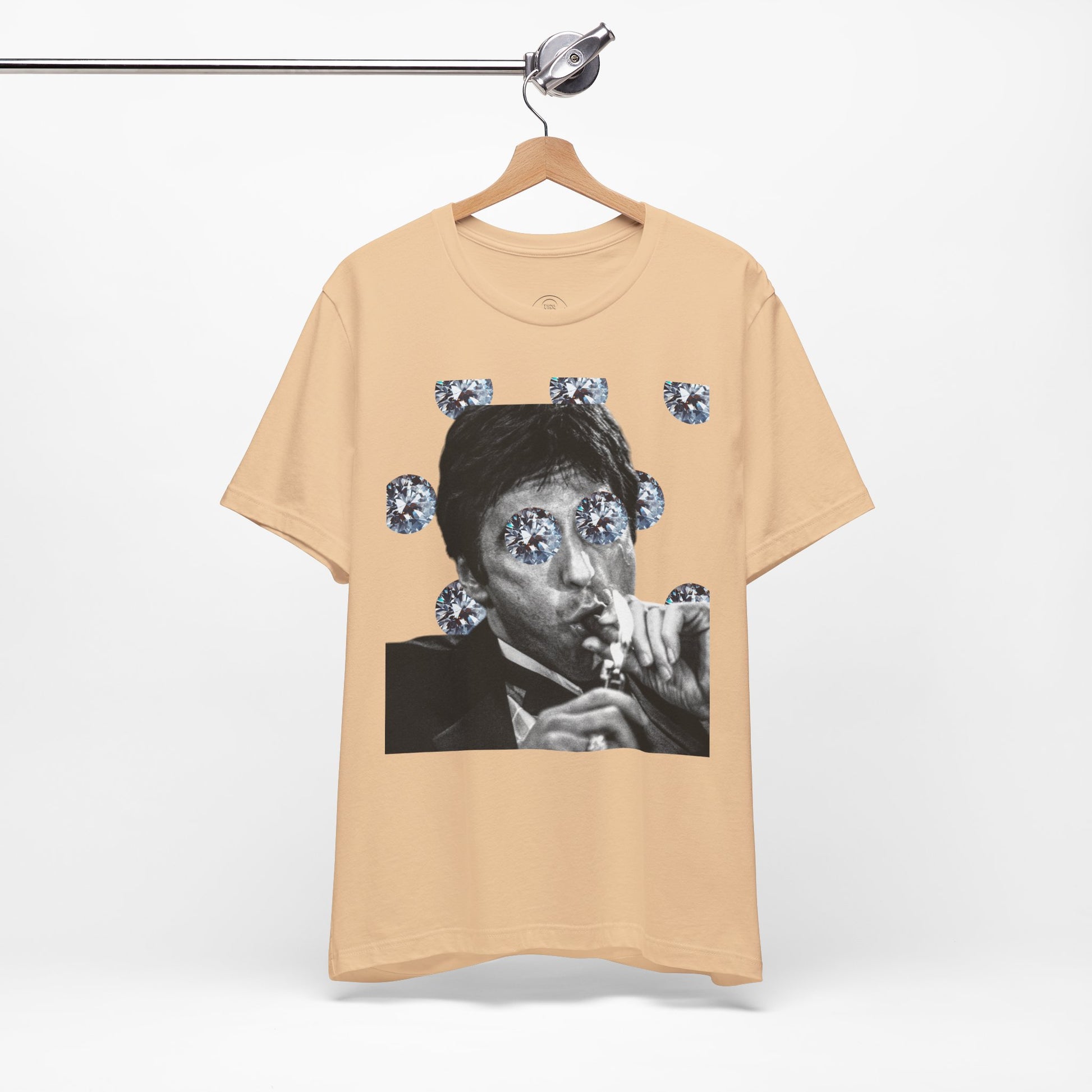 Beige t-shirt with a graphic of a person smoking and surrounded by diamonds on a hanger.